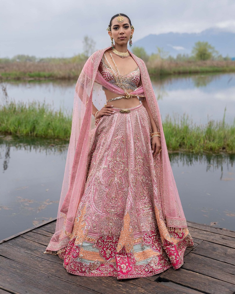 Photo of Bride wearing a bright pink lehenga with a white dupatta.